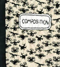 front cover of a fabric book made to look similar to Composition notebooks. The traditional black-and-white pattern has been replaced with embroidery of drones.