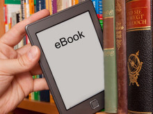 eReader being pulled off a shelf of books