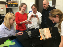 U-M Library staff working with ME 450 students on the linear book scanner.