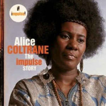 Album cover featuring a portrait photograph Alice Coltrane, a Black woman with an afro wearing large dangling earrings. She is not looking at the camera. 