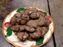 A plate of chocolate macaroons on a wooden table