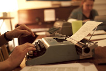 Close-up photograph of someone typing on typewriter