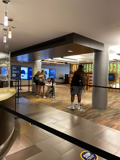 Image of the Shapiro Library Lobby, with a COVID check-in desk and students.